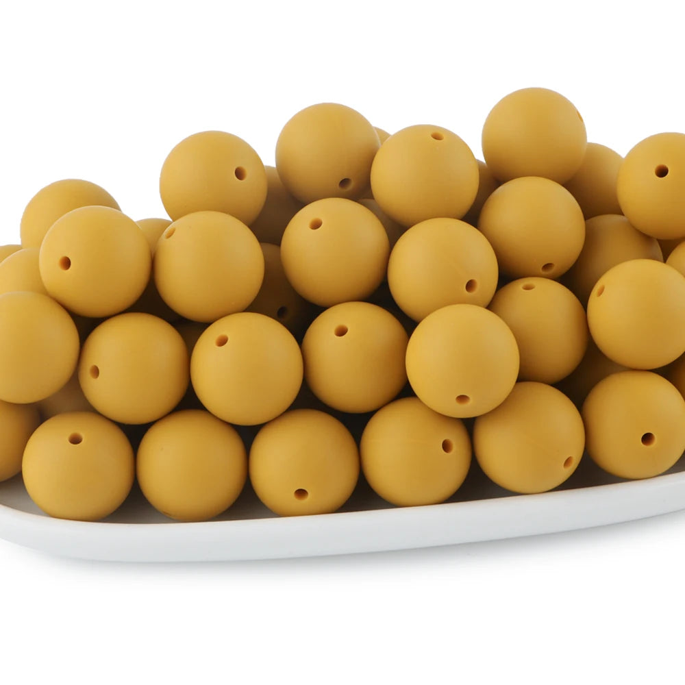 A pile of round, golden silicone beads for jewelry making and DIY crafts.