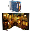 A wooden book nook kit featuring detailed miniature buildings and illuminated scenes.