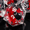 A close-up of red glitter resin dice shaped like pyramids and dodecahedrons, featuring black cat designs.