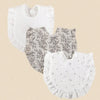 A set of three white cotton muslin baby bibs, featuring textured fabric and floral or star patterns.
