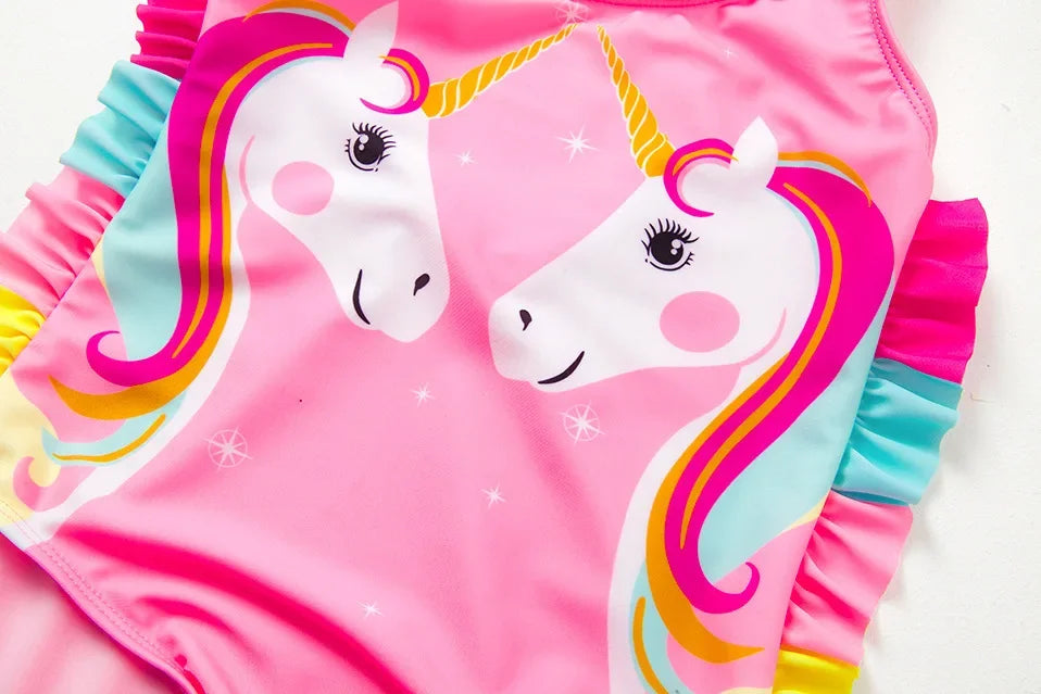 Pink and white unicorn one-piece swimsuit featuring a rainbow mane design.