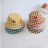 A collection of four bucket hats featuring different checkerboard patterns in yellow, brown, purple, and blue.