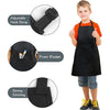 A boy wearing a black chef apron and hat set with an adjustable neck strap and front pocket.