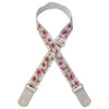 A beige woven guitar strap featuring a floral pattern and leather accents.