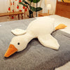 A large, white kawaii goose plush pillow with an orange beak resting on a gray fabric surface.