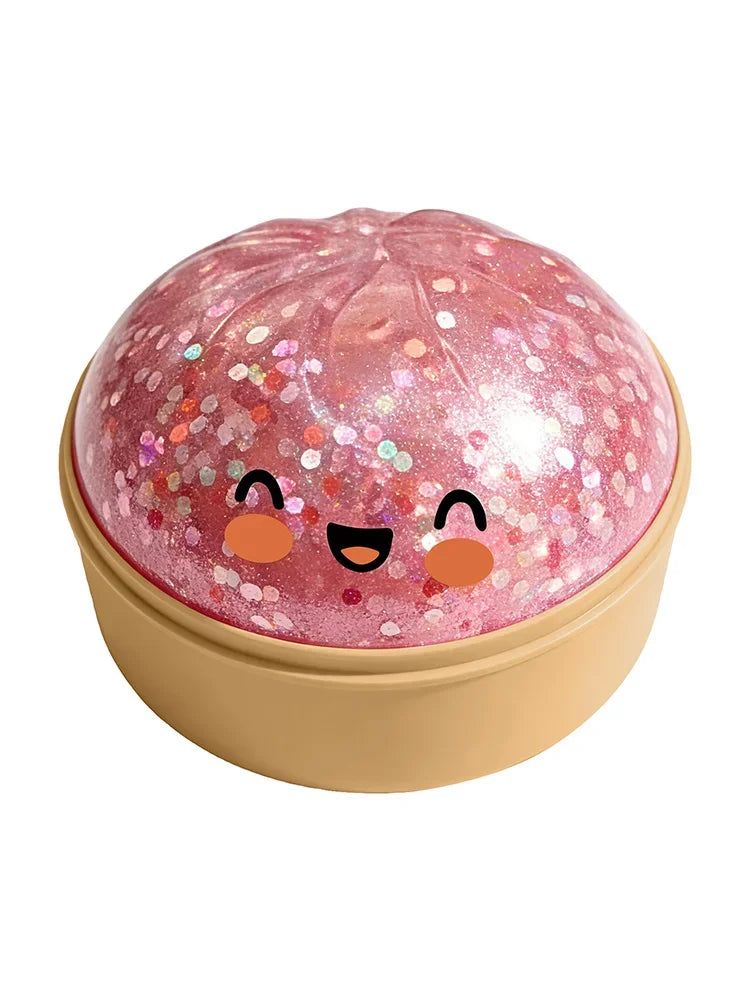 A pink, squishy stress relief toy shaped like a smiling dumpling face with glitter accents.