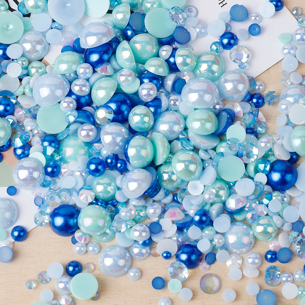 A colorful mix of iridescent blue and green resin rhinestones and pearls for craft and nail art projects.