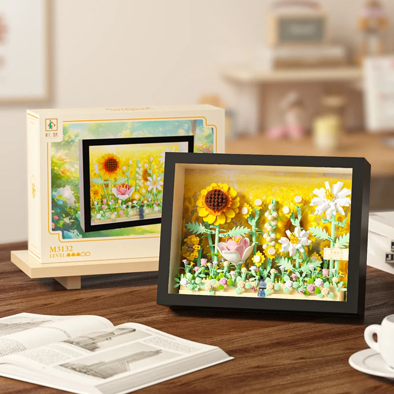 A framed display of a 3D flower building blocks set featuring colorful flowers and greenery.