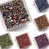 A collection of golden gradient glass beads in various colors and shades displayed in small plastic containers.
