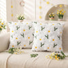 White faux fur pillow covers with embroidered yellow daisy designs displayed on a beige surface.