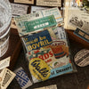 A collection of vintage decorative stickers for journaling and scrapbooking featuring various designs on a dark wooden surfac