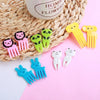 A set of kawaii mini fruit forks in various colors including pink, green, yellow, and white, displayed on a woven mat.