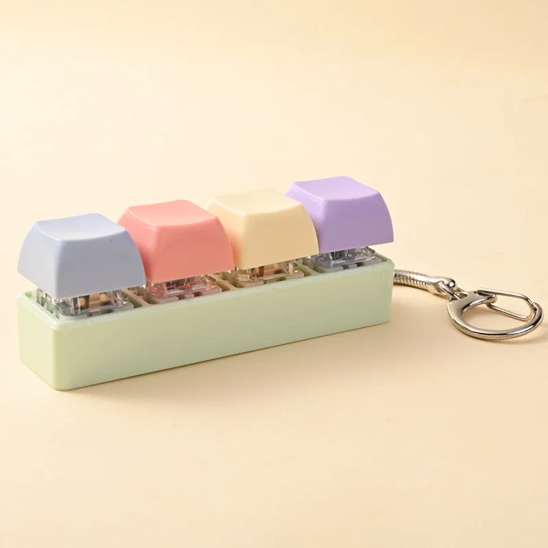 A colorful acrylic fidget keychain featuring four clicky key buttons in pastel shades.