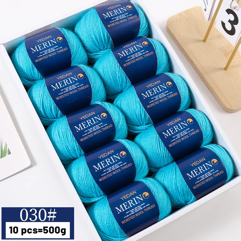 A box of 10 skeins of bright turquoise YEDAN MERINO worsted wool thread yarn for knitting projects.