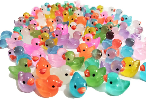 A large collection of glow in the dark miniature duck figurines in various bright colors.