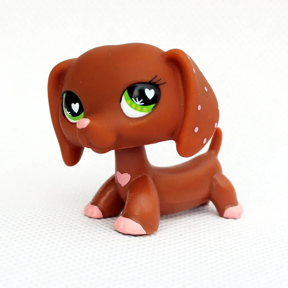 A small, brown dachshund bobblehead figurine with large green eyes and pink accents.