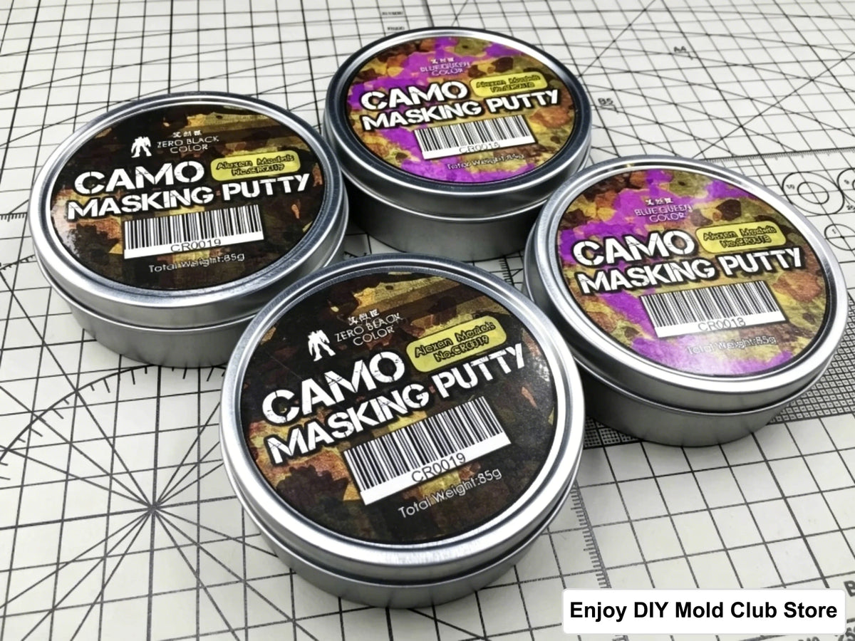 Four tins of Camo Masking Putty for model painting displayed on a grid background.