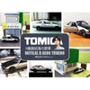 A collection of Tomica die-cast sports car models, including a black and white coupe and an open-top vehicle.