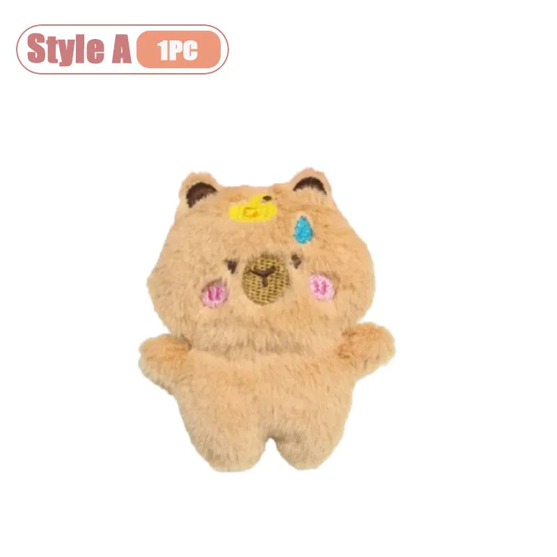 A fluffy, light brown capybara plush toy with yellow and blue accents.
