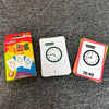 A set of Telling Time flash cards and a colorful card box are displayed on a gray fabric surface.