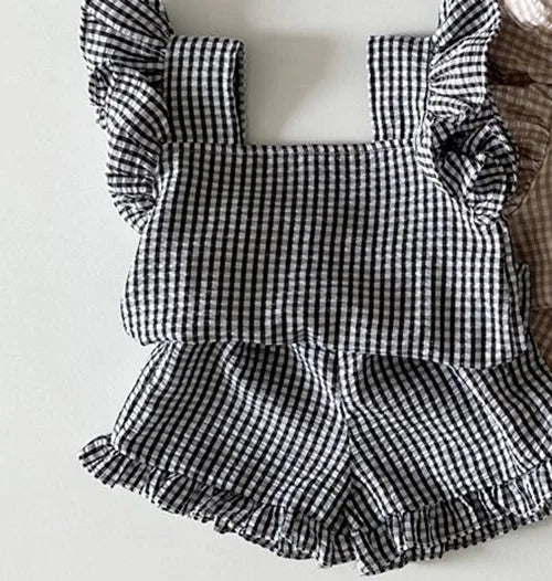 A black and white gingham ruffle top and shorts set for a baby girl summer outfit.