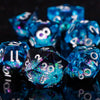 A close-up of a pile of bright blue resin dice on a dark surface.