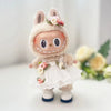 A small, fluffy rabbit doll wearing a white wedding dress outfit with floral accents.