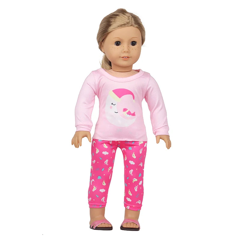 A pink unicorn pajama set for an 18-inch doll featuring a long-sleeved top and matching patterned pants.