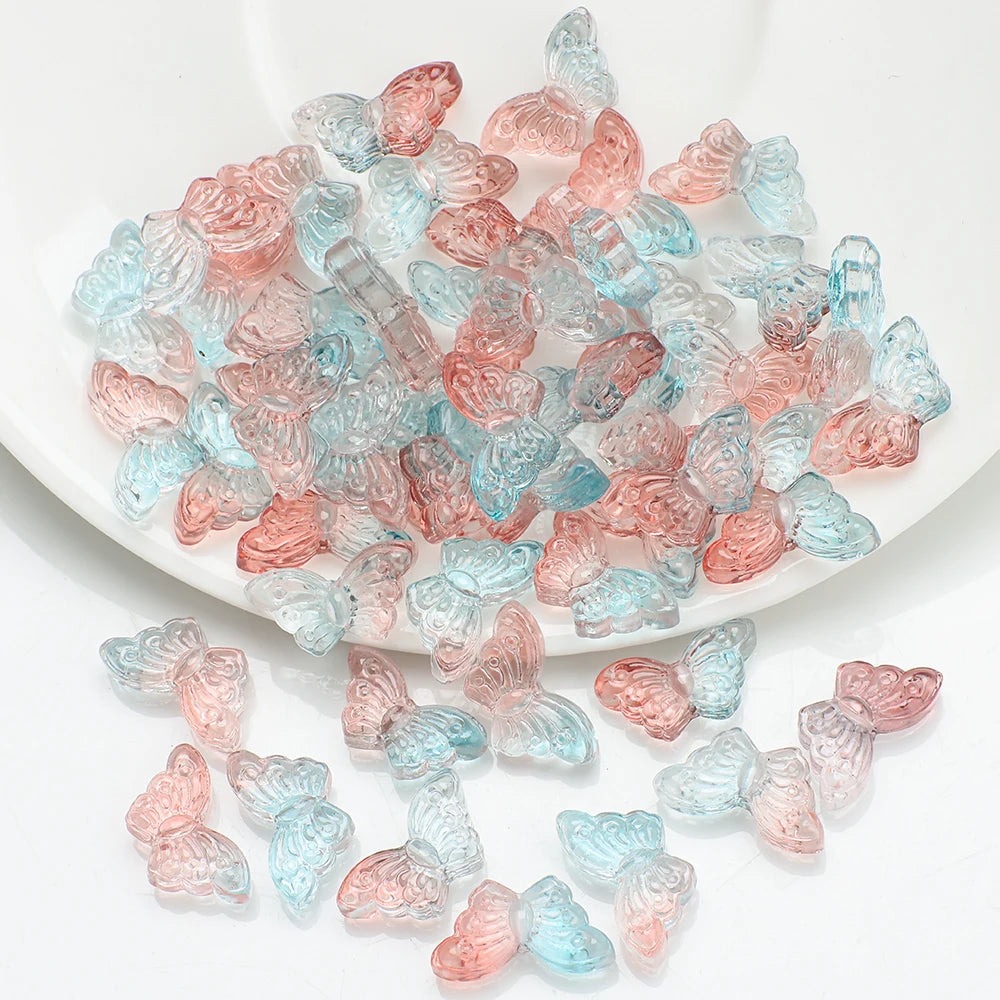 A pile of translucent pink and blue butterfly glass beads for jewelry making