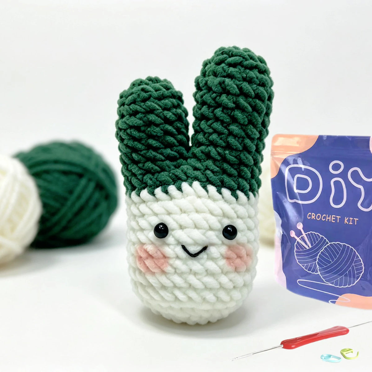 A green crochet kit featuring a textured animal shape, including yarn and a crochet hook.