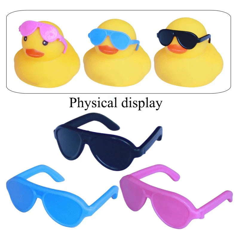 A set of rubber duck accessories including sunglasses and hats in various colors like yellow, blue, black, and pink.