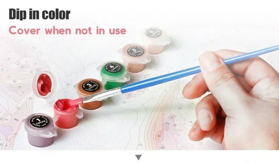 A hand dips a paintbrush into various colors of paint to cover a canvas, demonstrating the dip in color feature.