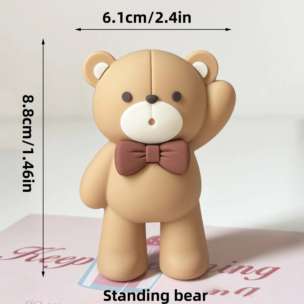 A light brown teddy bear standing decoration with a pink bow, measuring 8.8cm tall.