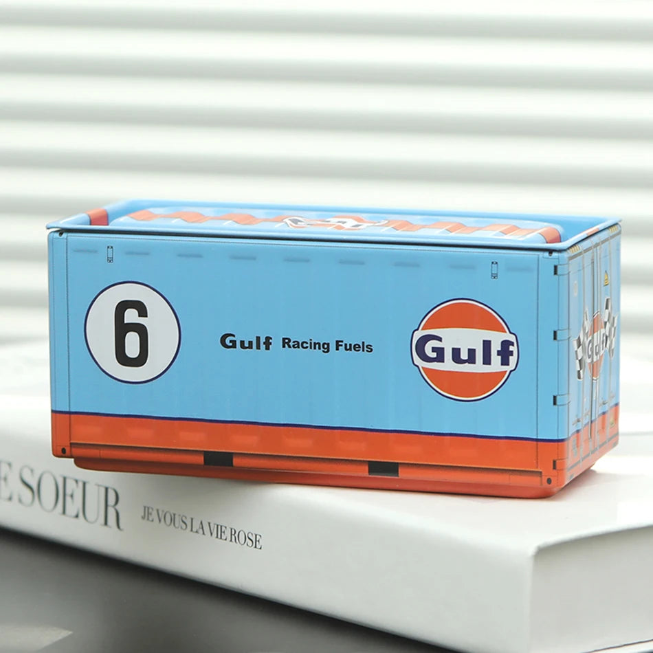 A rectangular blue and orange storage box labeled Gulf Racing Fuels resting on a white book.