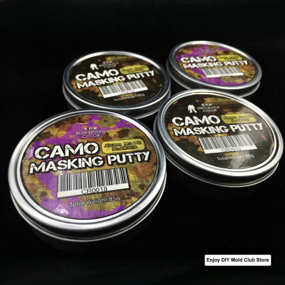 Three tins of Camo Masking Putty for model painting displayed on a black background.