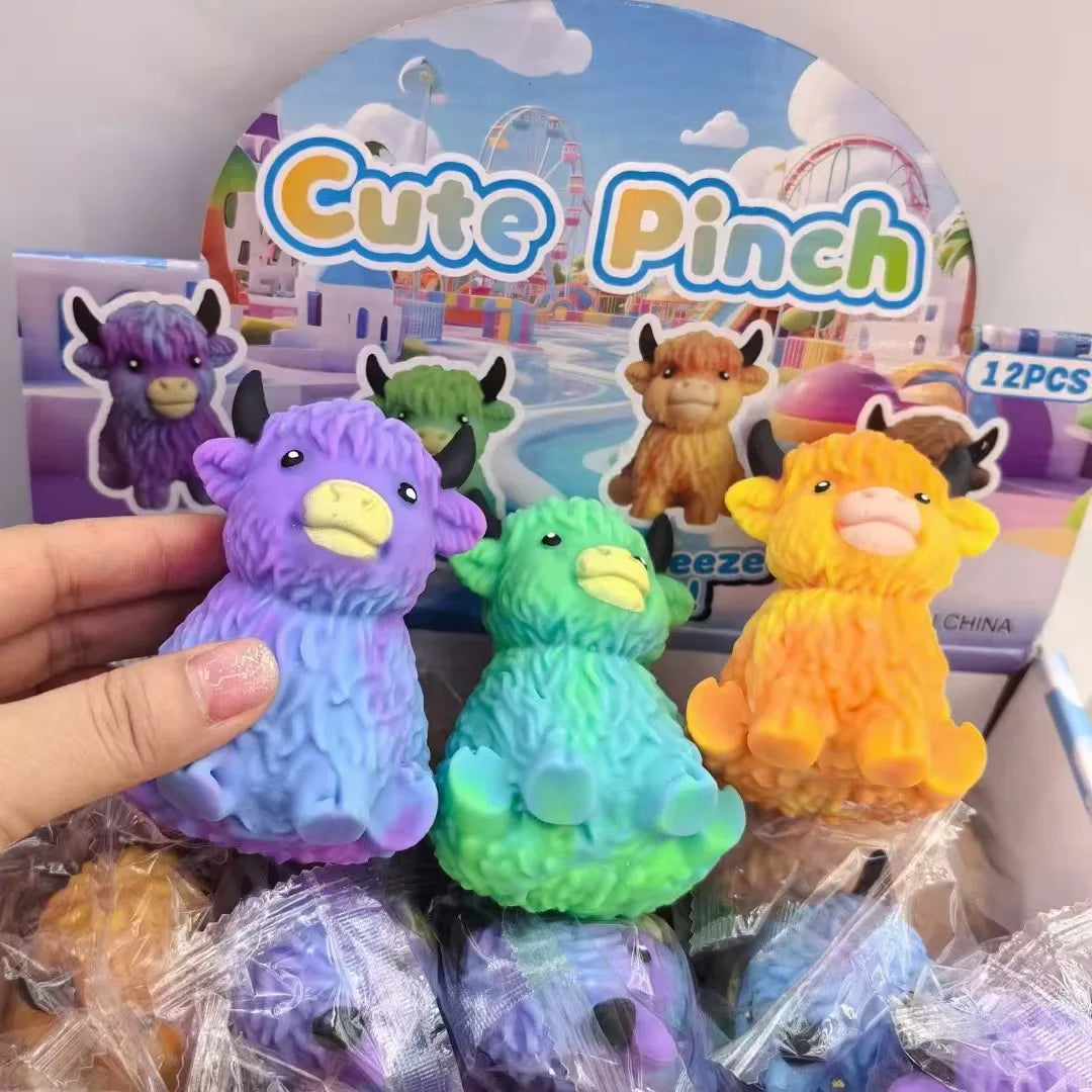 A hand holds several colorful cute pinch squishy toys featuring Highland cow designs.