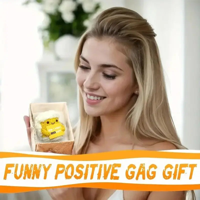 A young woman holds a handmade crochet beer mug buddy with a funny card.