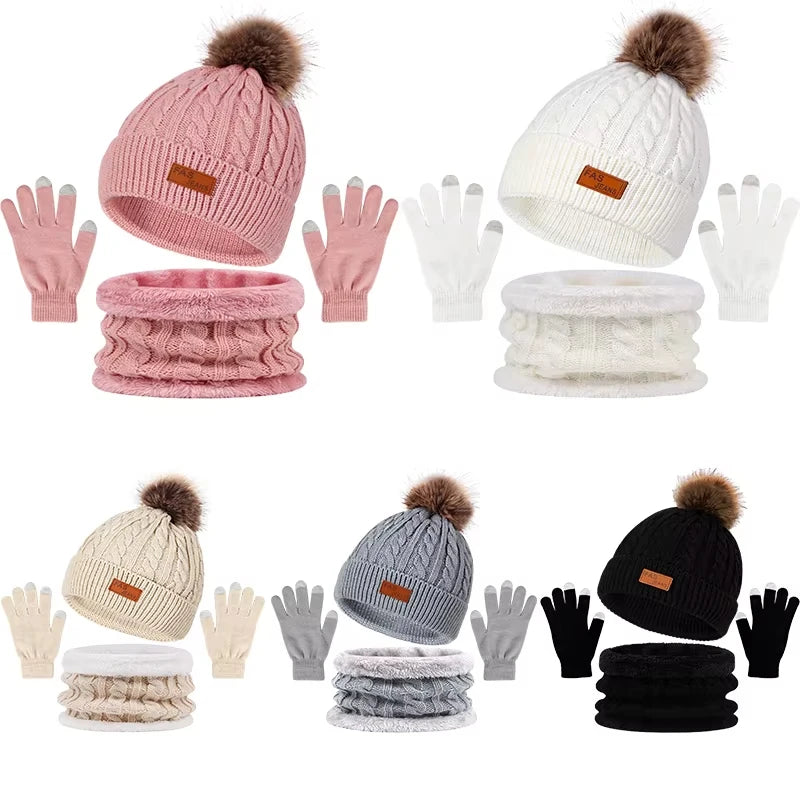 A set of women's knit winter hat, scarf, and gloves in various shades of pink, white, gray, and black with faux fur pom-poms.