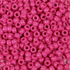 A close-up view of a large pack of bright pink pony beads for jewelry making and craft projects.
