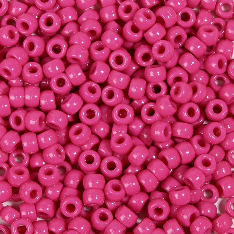 A close-up view of a large pack of bright pink pony beads for jewelry making and craft projects.