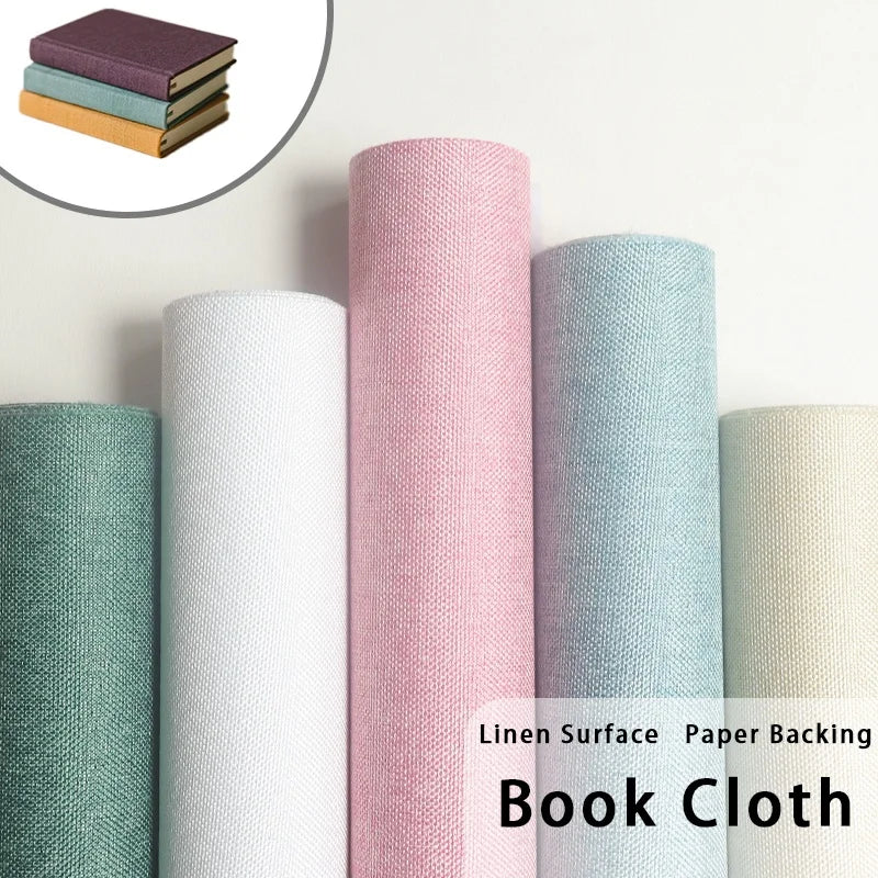 Rolls of linen book cloth in various shades including pink, mint green, and beige.