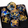 A collection of blue resin dice with gold accents, including d6s and d10s, displayed in a dark box.