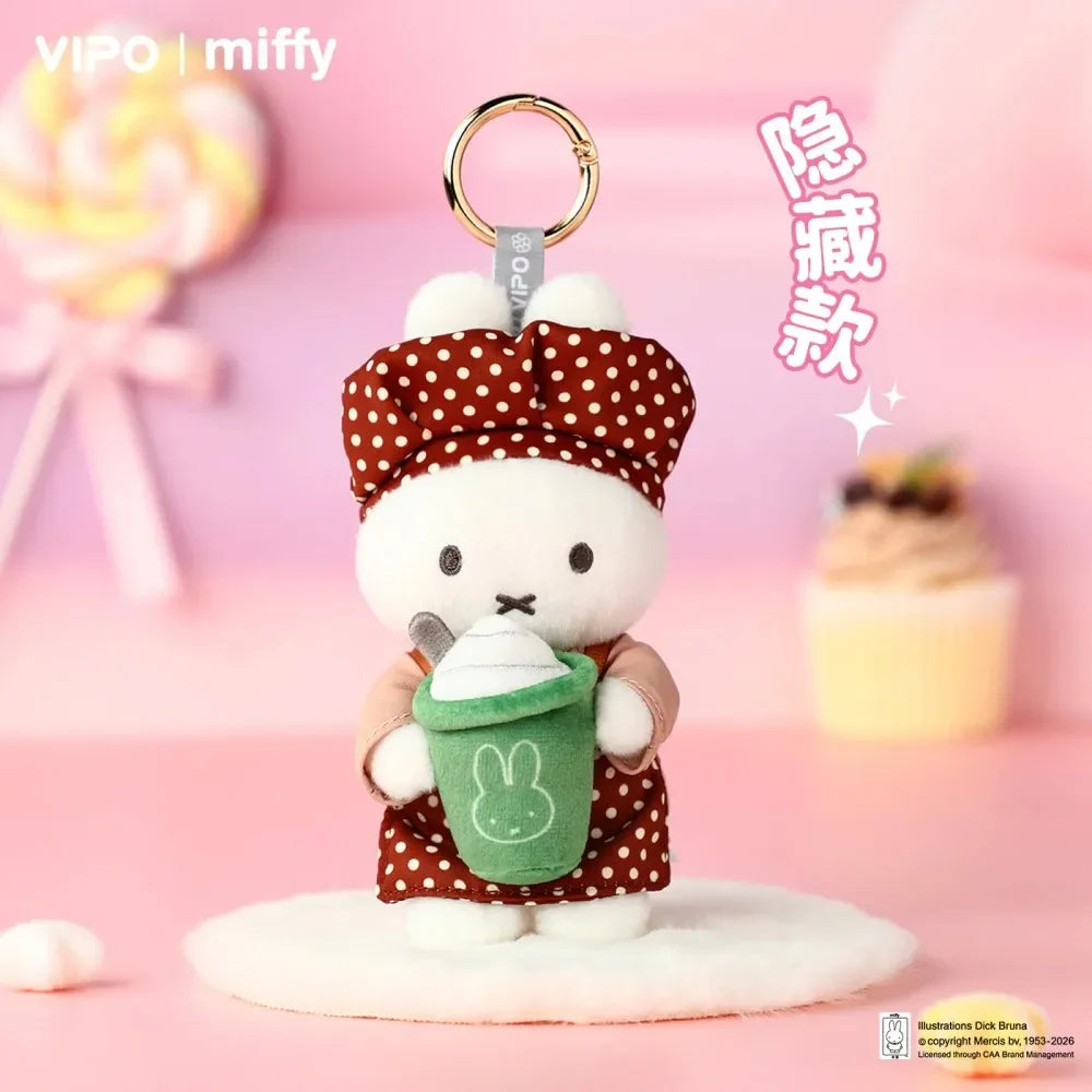 A cute white Miffy plush toy dressed as a baker, holding a green cupcake, displayed on a pink background.