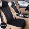 A black universal car seat protector with plush anti-slip backing installed in a light beige car seat.