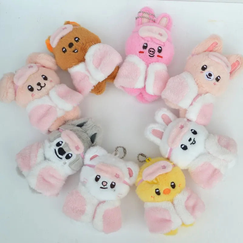 A collection of pink and orange cartoon animal plush keychains arranged in a circle.