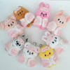 A collection of pink and peach cartoon animal plush keychains arranged in a circle.