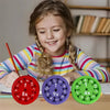 A young girl is holding three colorful math fidget spinners showing multiplication facts on a wooden table.