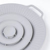 A round silicone spill stopper lid with numerous small holes, shown in a light gray color.