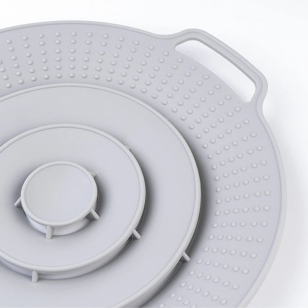 A round silicone spill stopper lid with numerous small holes, shown in a light gray color.