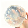 A translucent, squishy stress ball shaped like a coconut, being held in a hand.